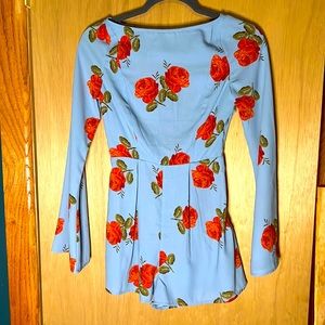 NWT Urban Outfitters Romper. Size: XS. Blue with red floral pattern. Open Back